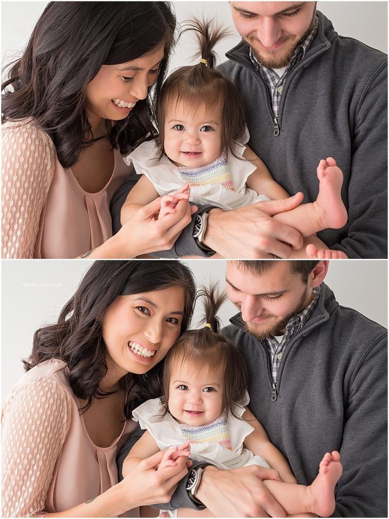 A family shares tender moments together during an indoor photo session with soft lighting.