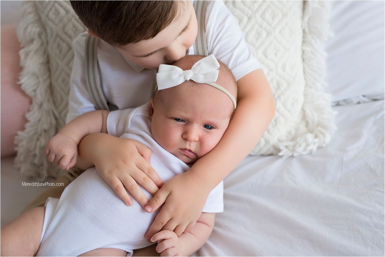 A series of tender moments between parent and baby lying together on white bedding.