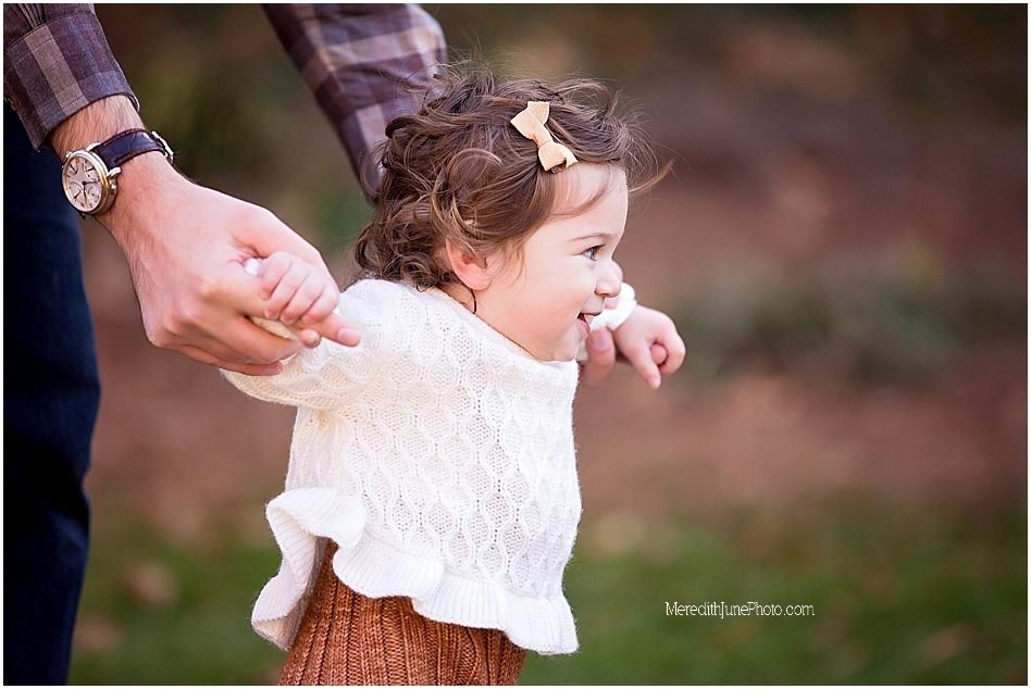 Candid family moment captured in warm outdoor setting during fall season.