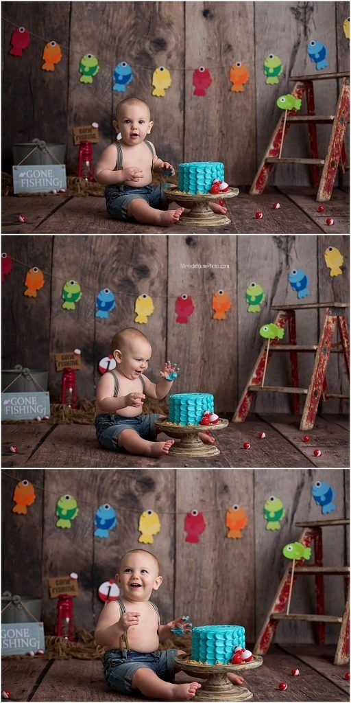 Colorful fishing-themed cake smash photo setup with wooden backdrop and decorative fish garland.