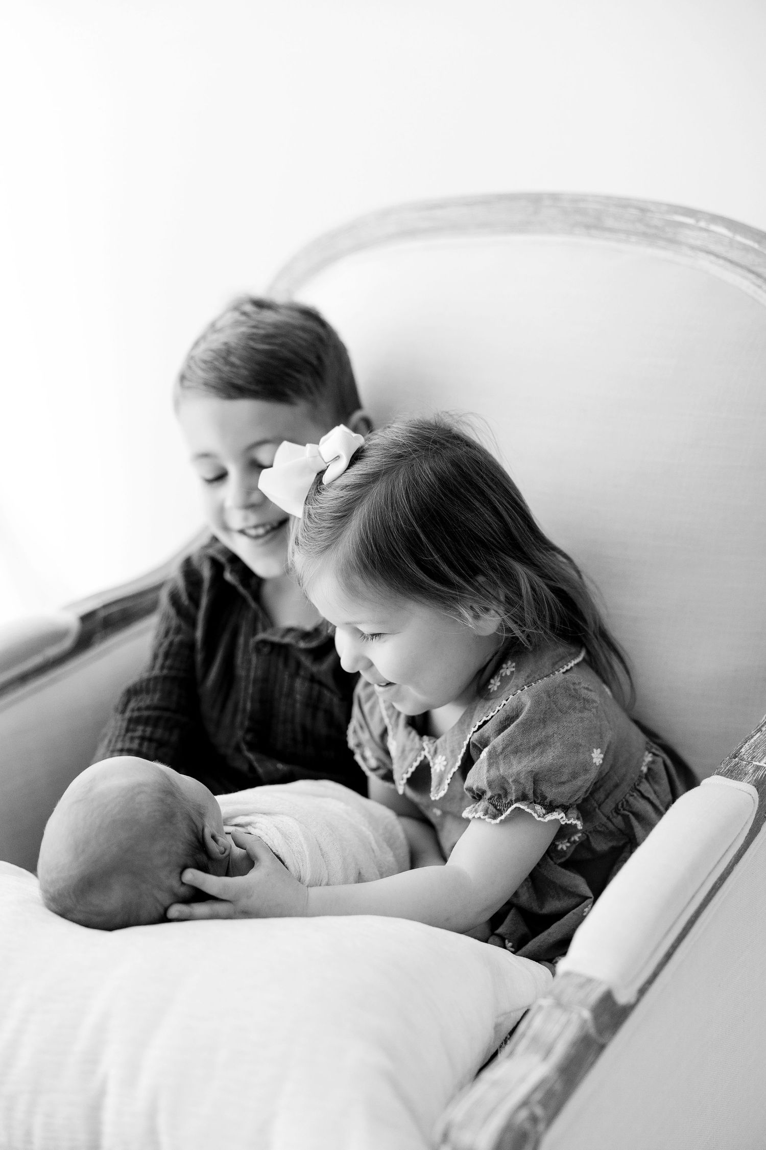 A black and white photo series showing tender moments between a parent and child reading together in bed.