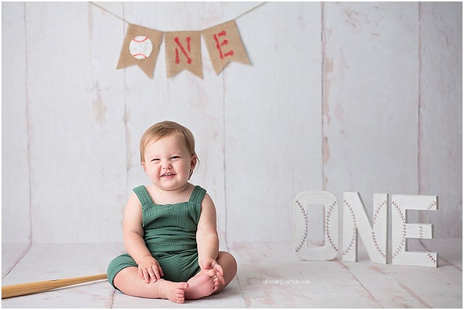 A series of milestone photos showing a baby's first year growth against a white backdrop with decorative banners.