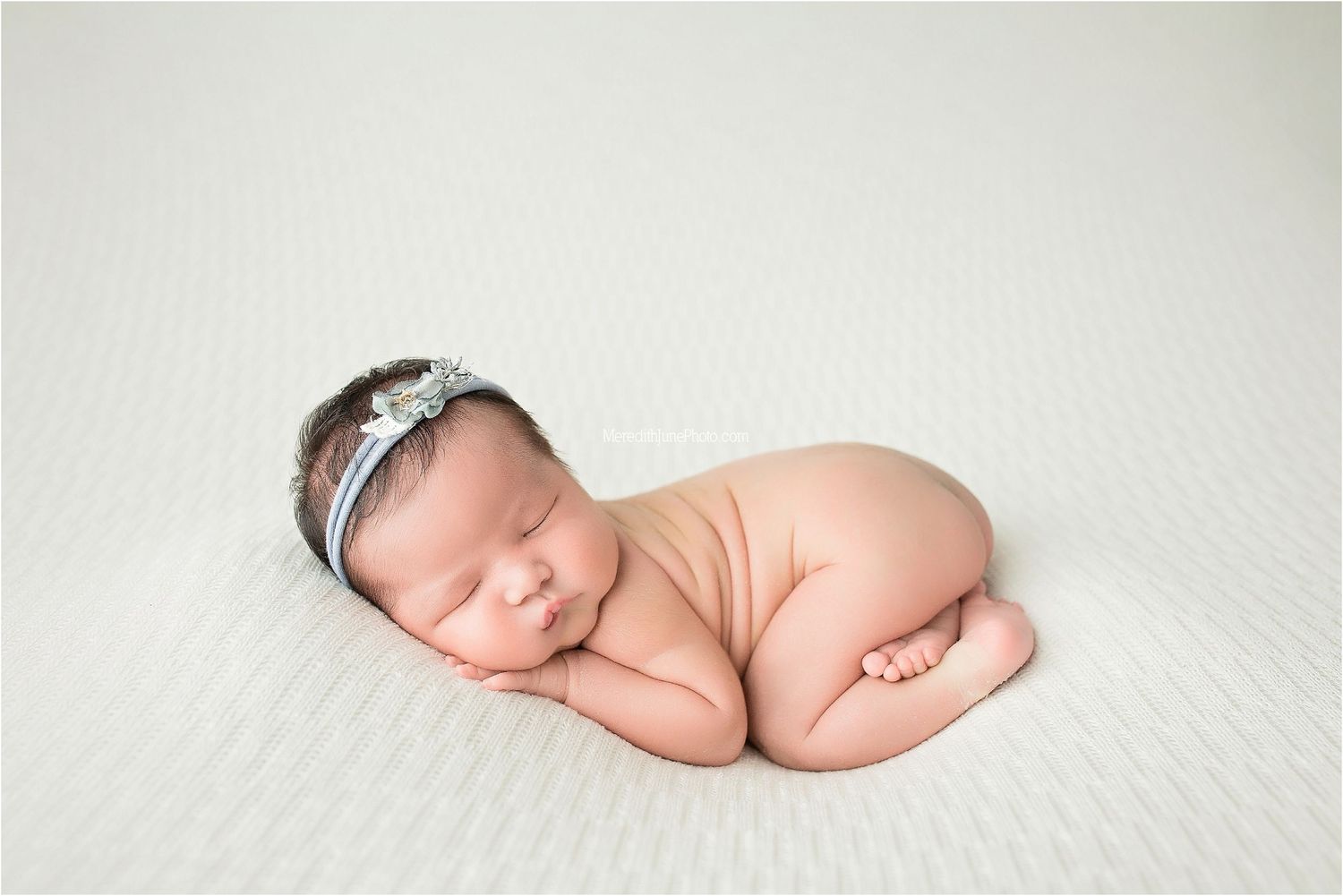 A series of peaceful newborn baby portraits on soft white fabric showing different sleeping positions.