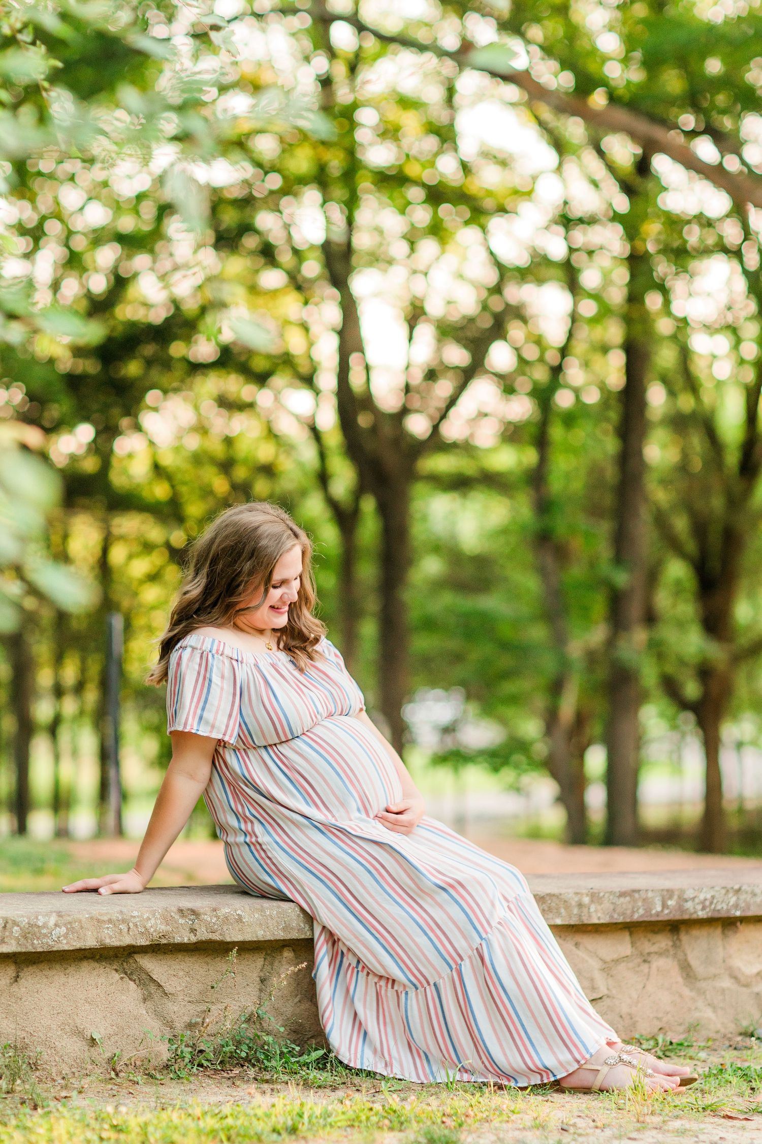 A series of photos showing a person in a striped dress sitting on a stone wall in a sunlit wooded park setting.