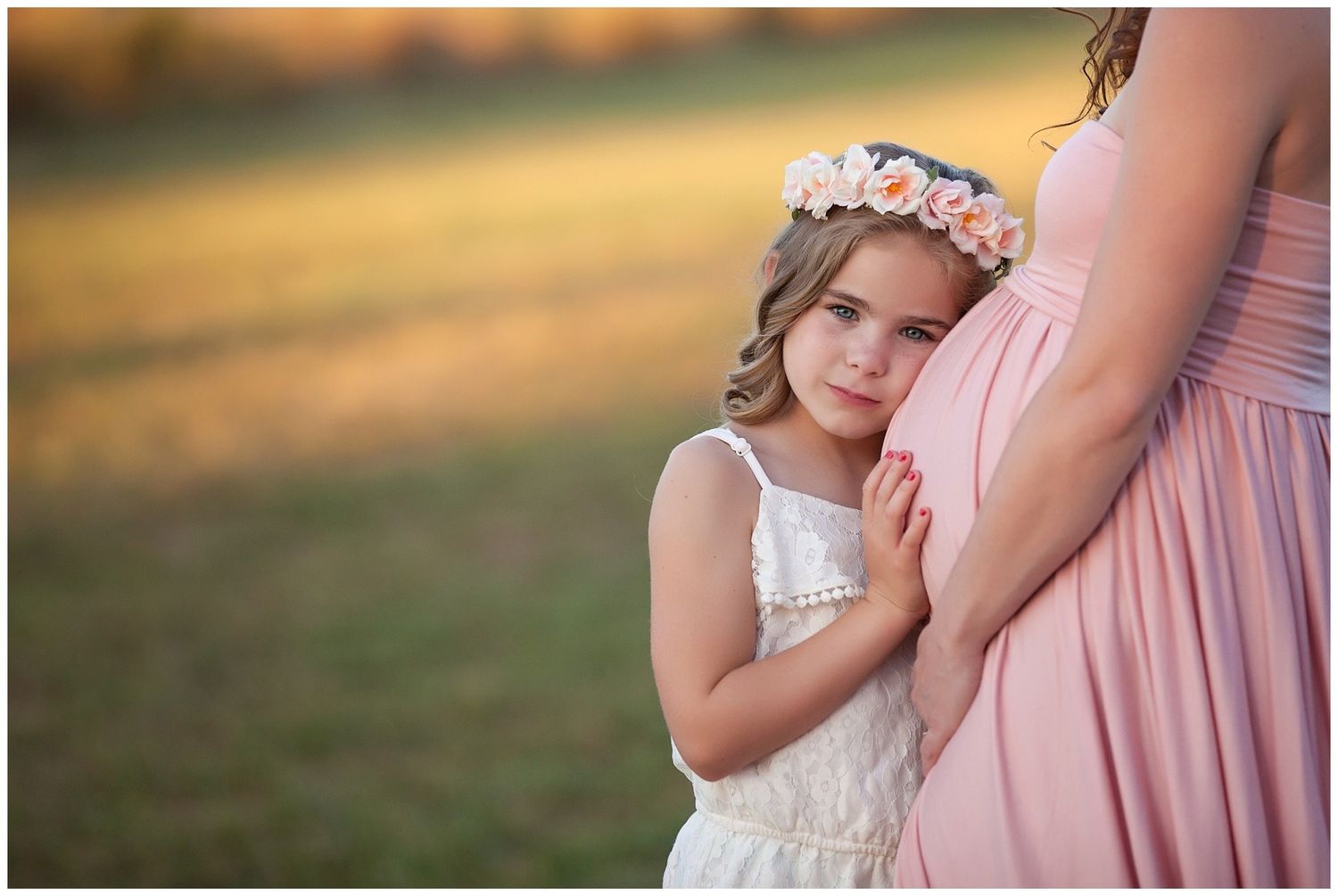A series of tender maternity photos showing a woman in pink and a young girl in white against soft natural lighting.