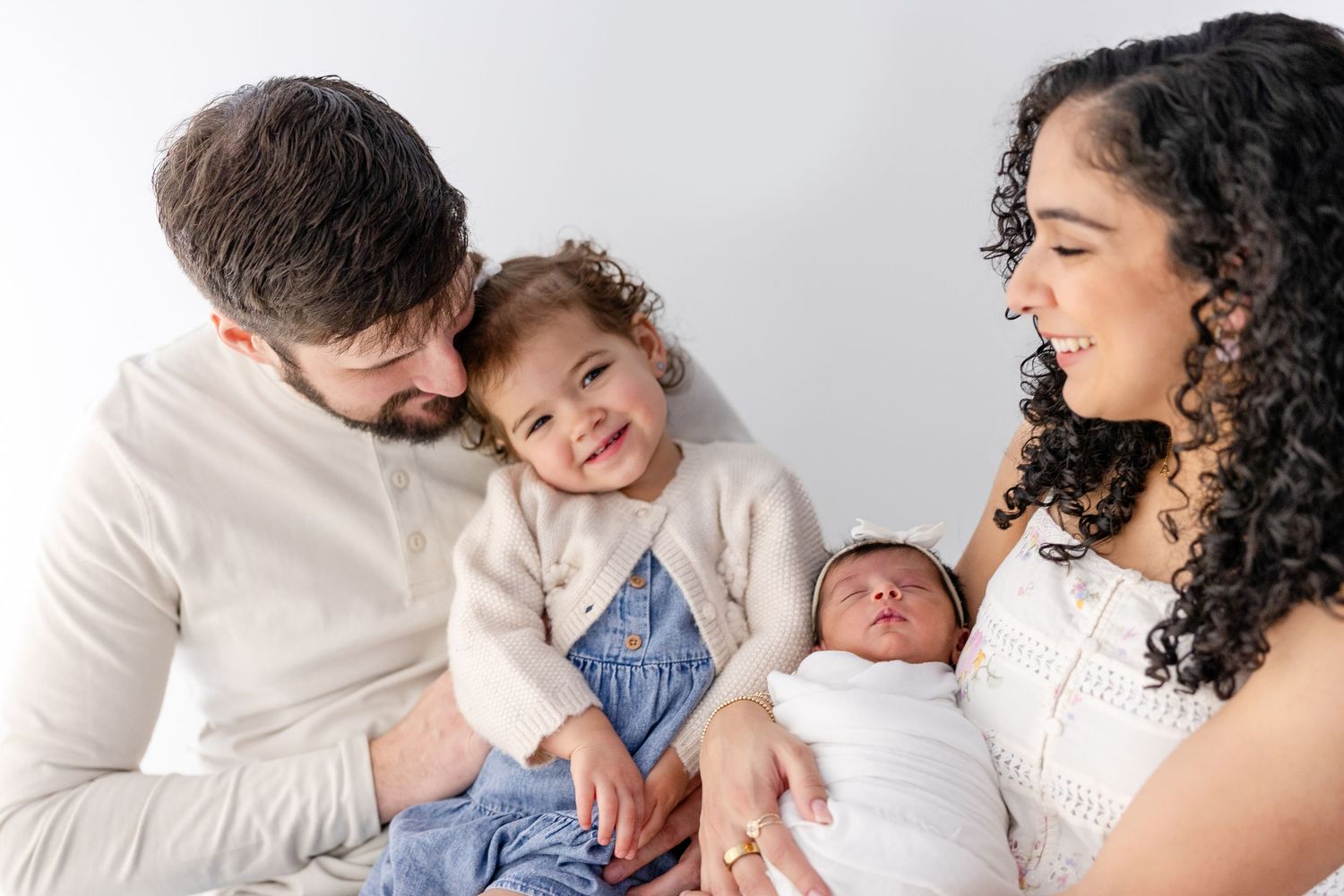 A series of intimate black and white family portraits showing tender moments between parents and their newborn baby.
