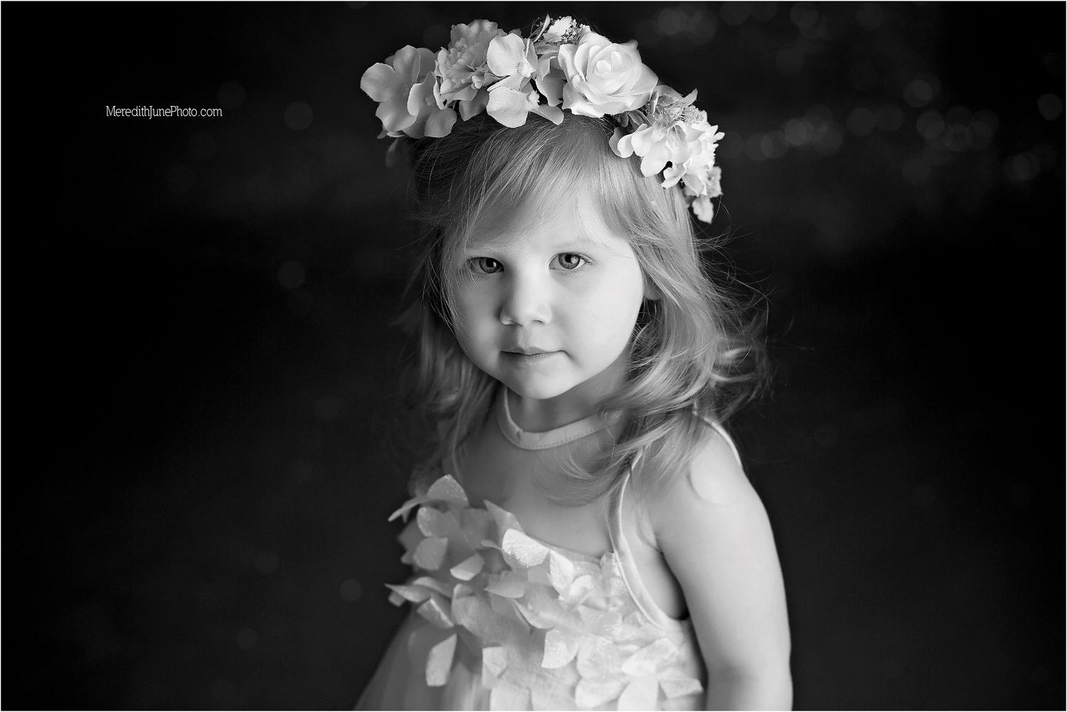 A series of black and white portraits showing a child in white dress with soft lighting and dreamy expressions.