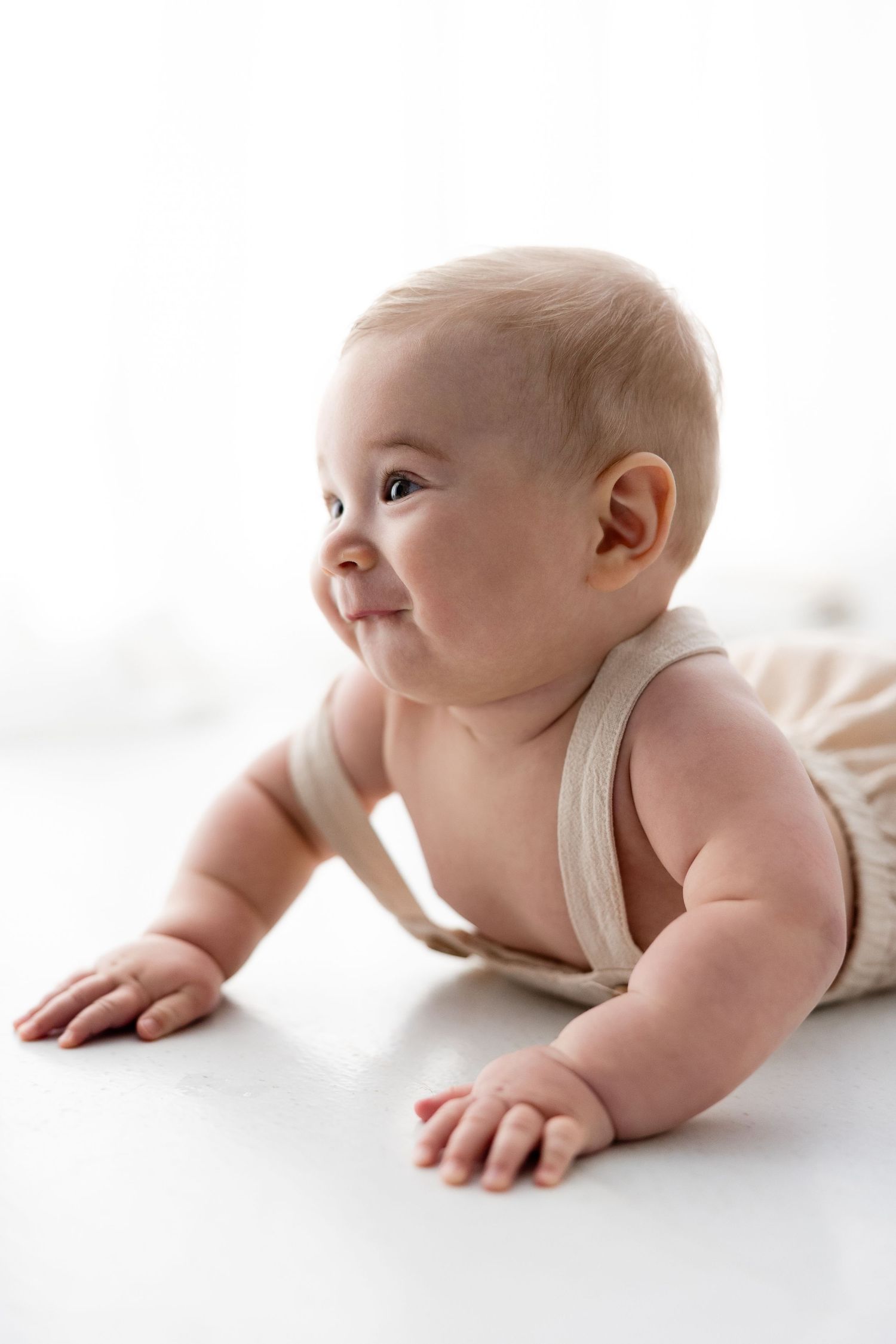 Four sequential images showing a baby crawling on a white background, demonstrating progressive movement from left to right.