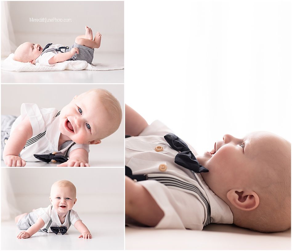 Baby in white onesie lying on soft blanket while playing with black and white contrast cards for development.