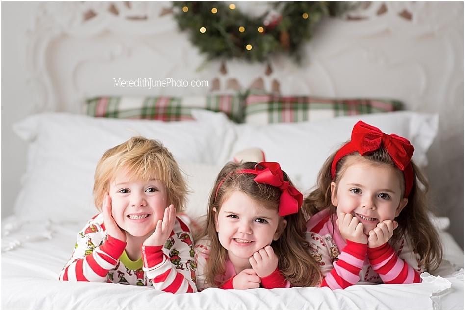 Seven holiday themed photos show children in red and white outfits posing on white bedding with Christmas decorations.
