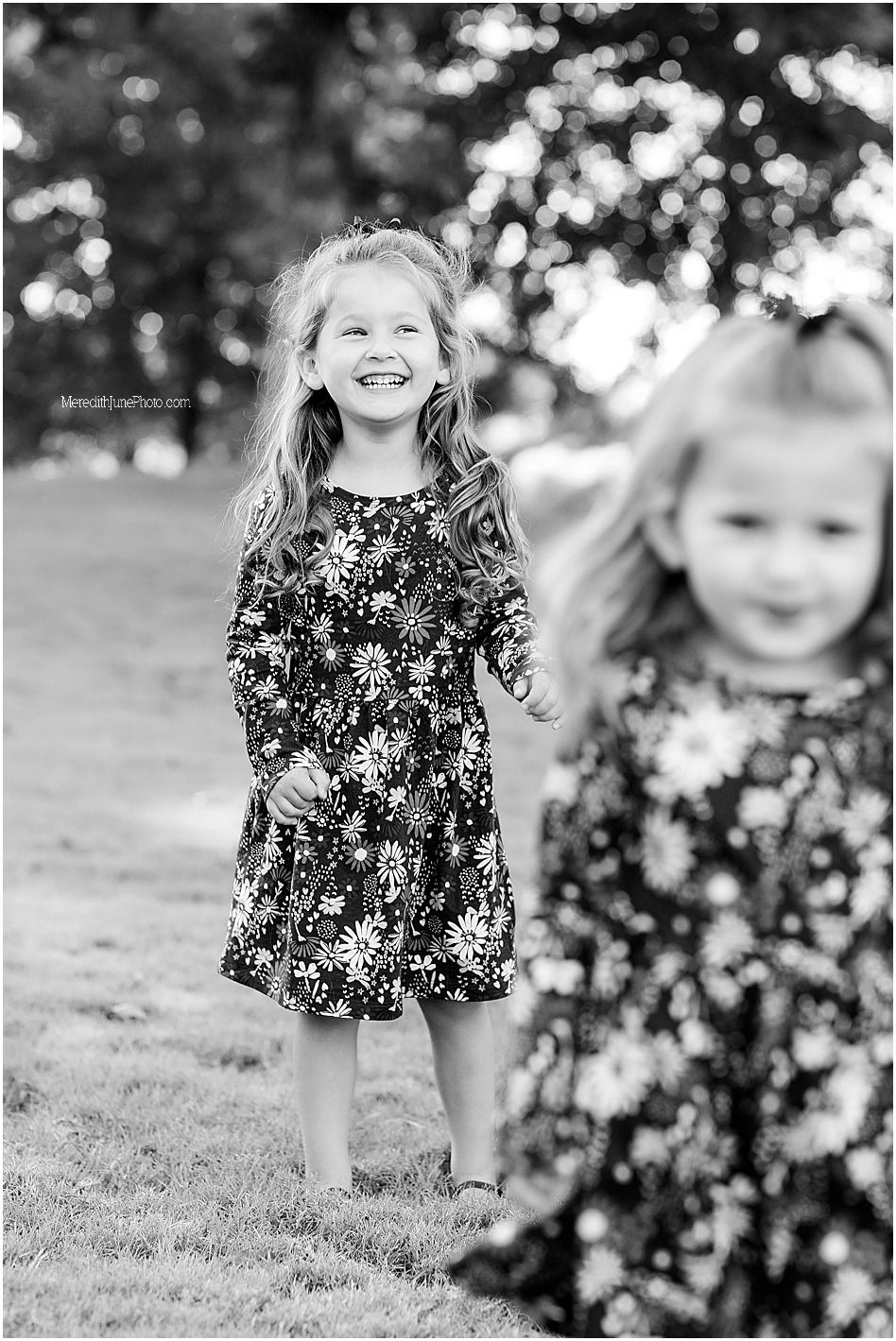 Black and white portrait series showing joyful moments of a child playing outdoors in a floral dress.