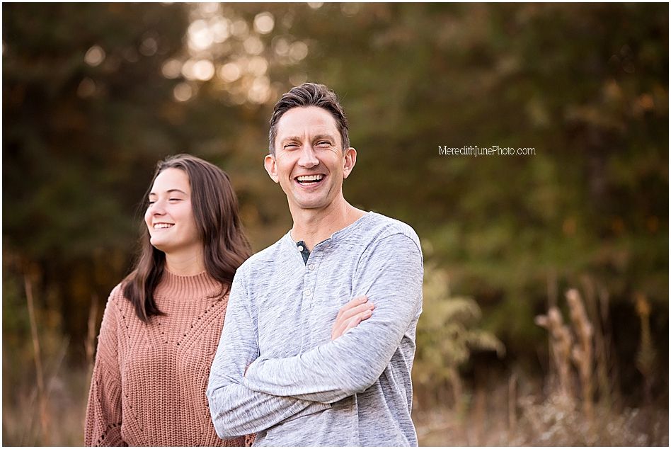 A couple laughs together during an outdoor autumn photo session.