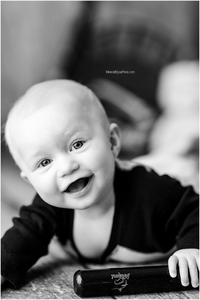 Black and white photo sequence showing a baby's joyful expressions and sweet smiles while wearing dark clothing.