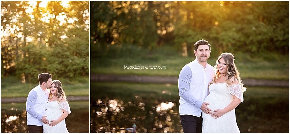 A couple embraces in a romantic outdoor setting during golden hour with sunlight filtering through trees.
