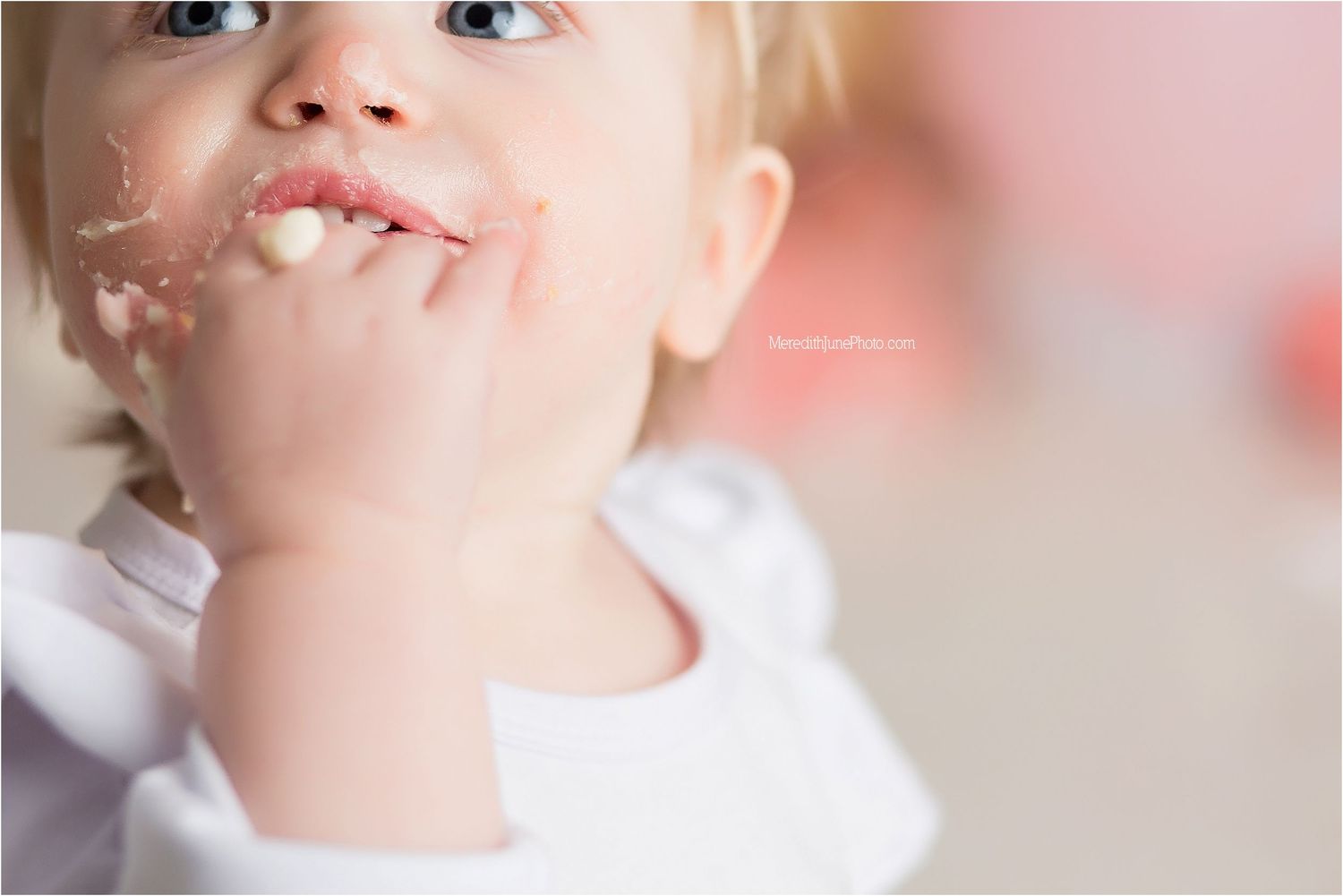 Close up beauty portrait with soft pink lighting and natural makeup showing lips and skin texture details.