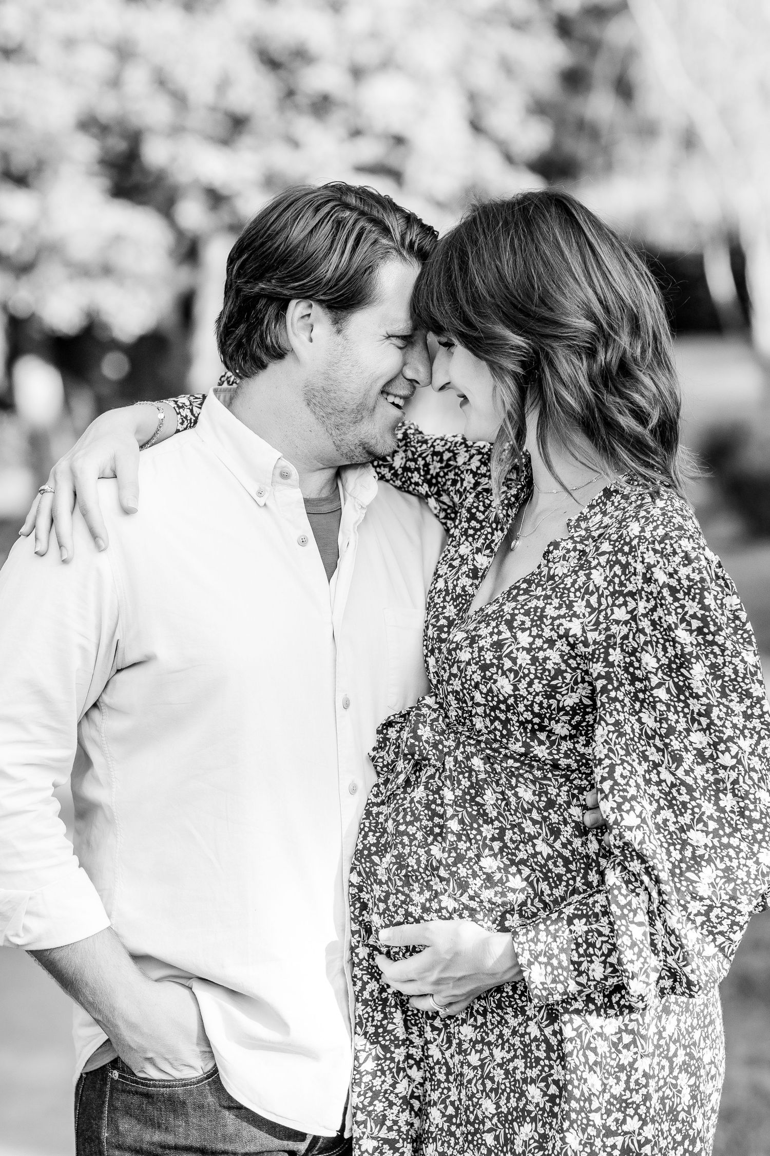 A romantic black and white photo series showing a couple in a floral dress and white shirt sharing tender moments.