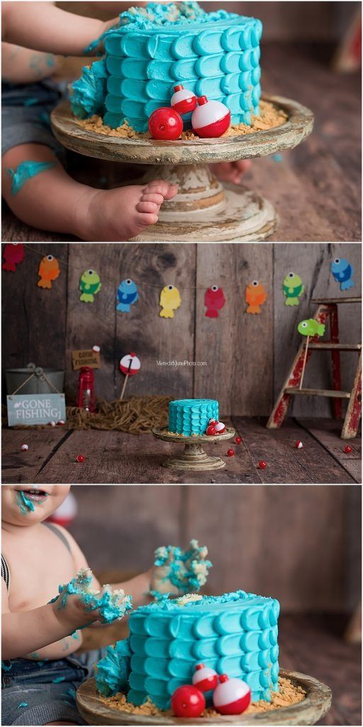 Fishing-themed cake decorations including colorful bobbers and fish hang against a weathered wooden backdrop.