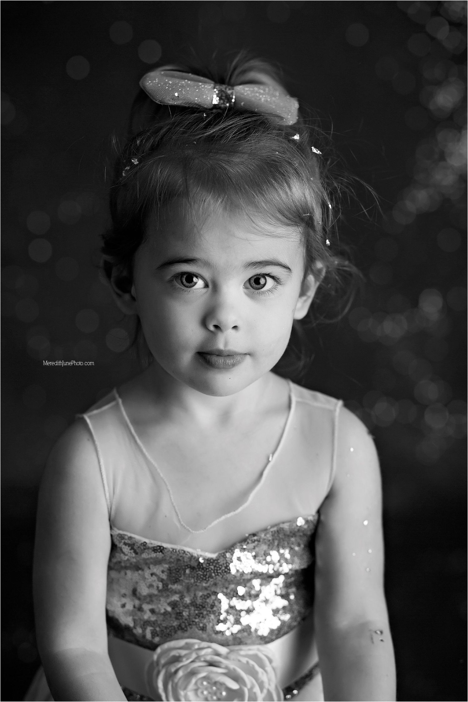 A series of black and white portrait photos showing a child in a sequined dress with expressive poses.