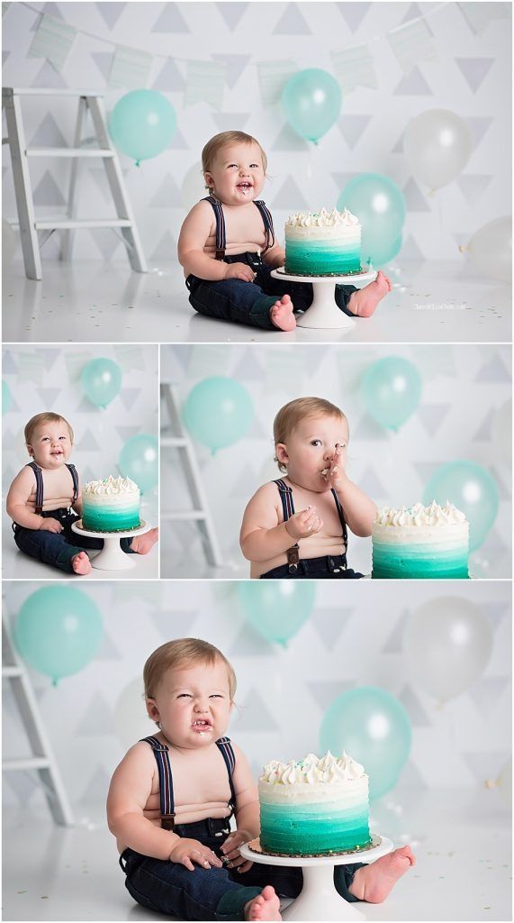 Cake smash photo session with teal balloons and white backdrop featuring a baby in navy overalls.