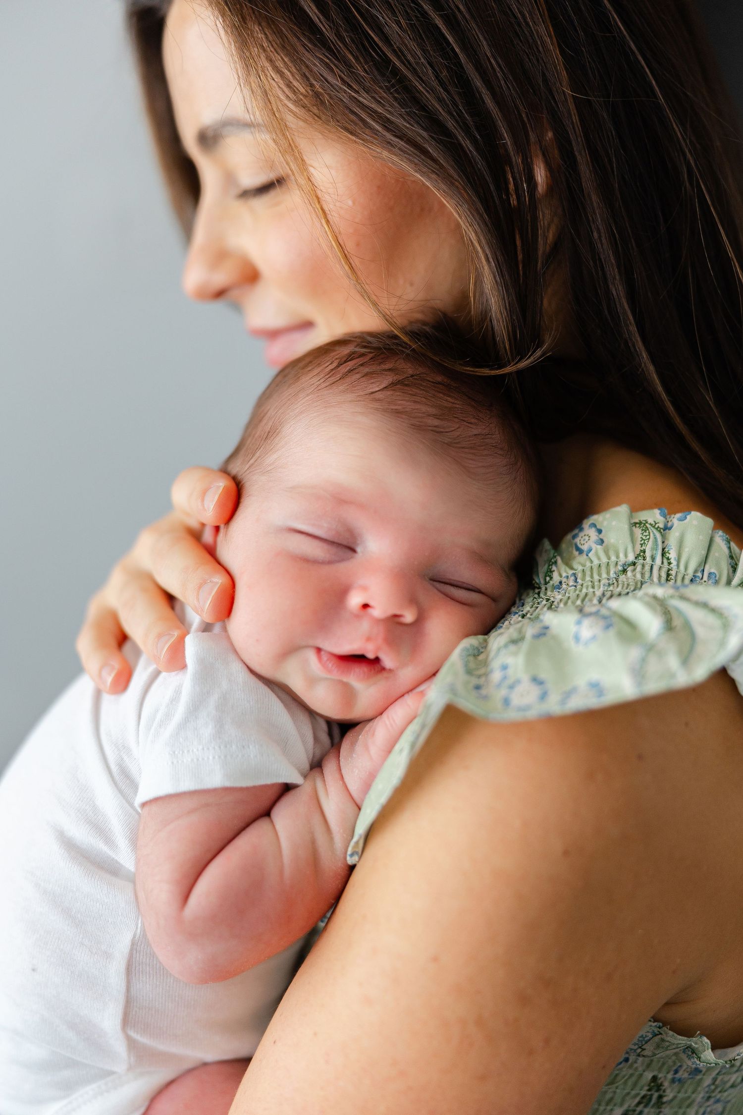 A tender moment between parent and sleeping baby in soft, natural light.