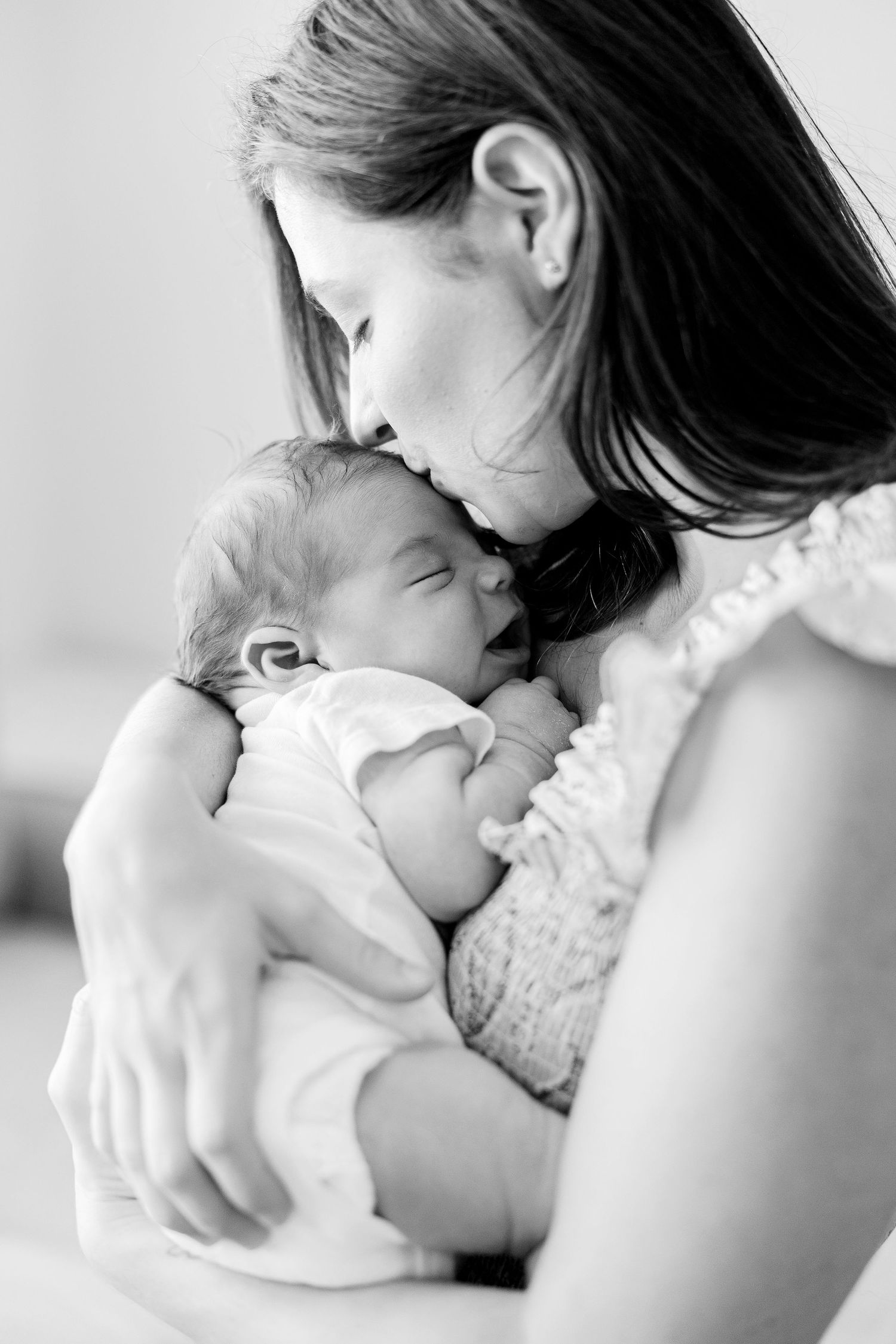 Black and white series showing tender moments between parent and baby in soft natural light.