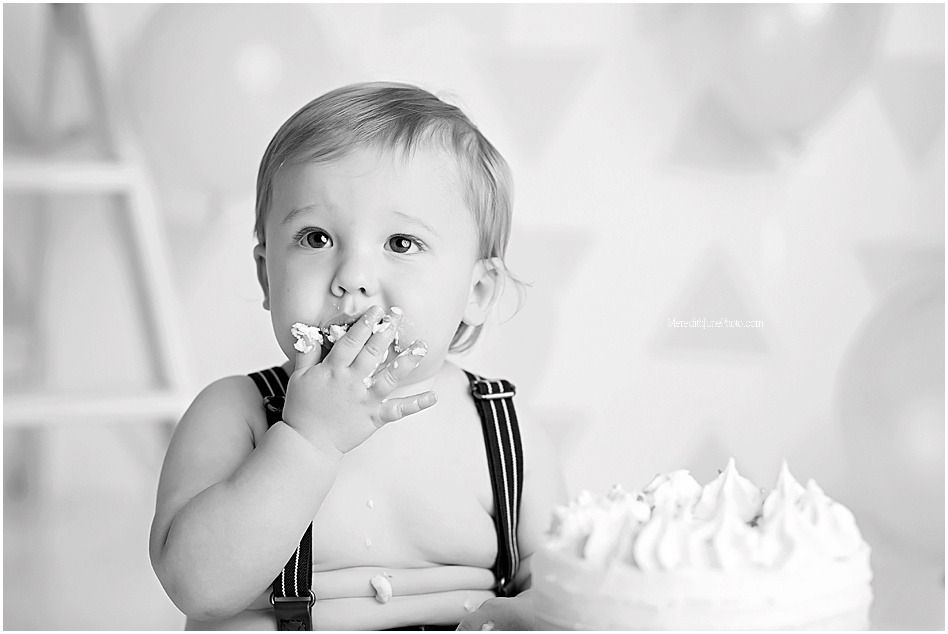 Black and white photo series of a baby in overalls making playful expressions and poses.