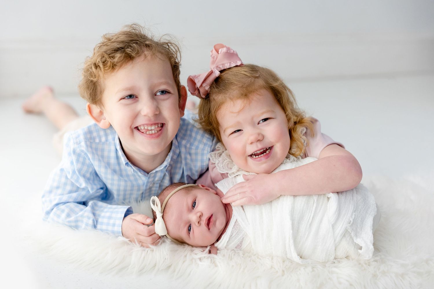 A series of joyful family photos showing siblings lying together on white bedding while smiling and hugging.