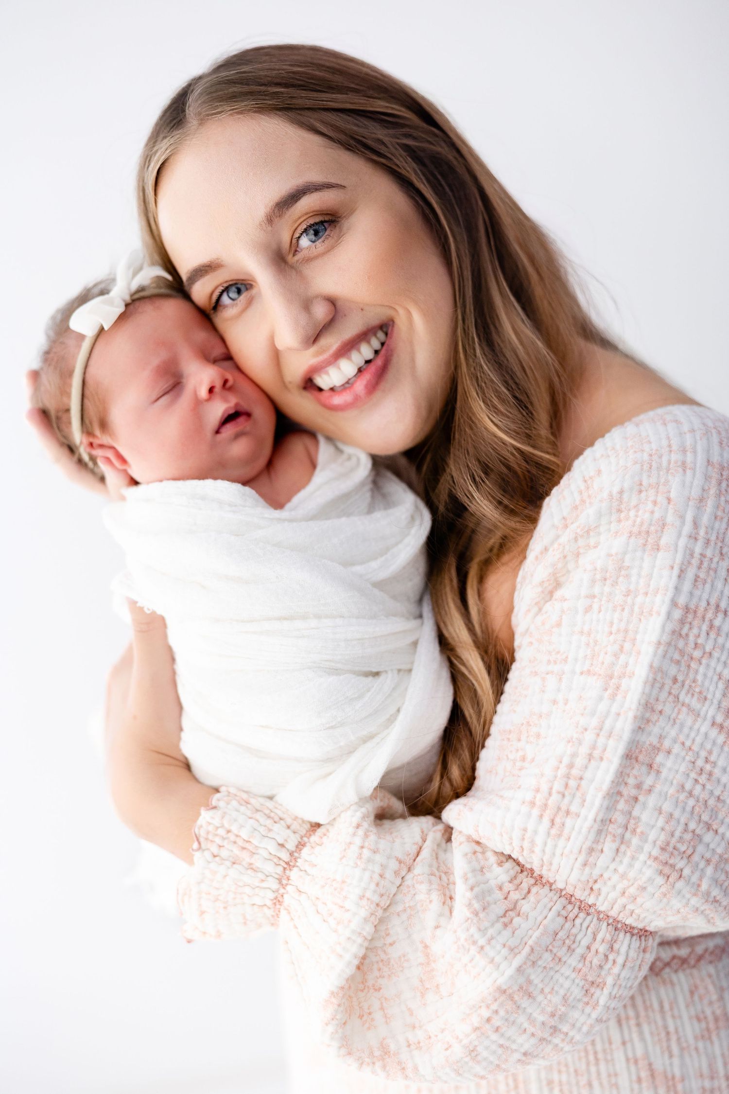 A series of tender embraces and joyful moments captured in soft, warm lighting against a white backdrop.