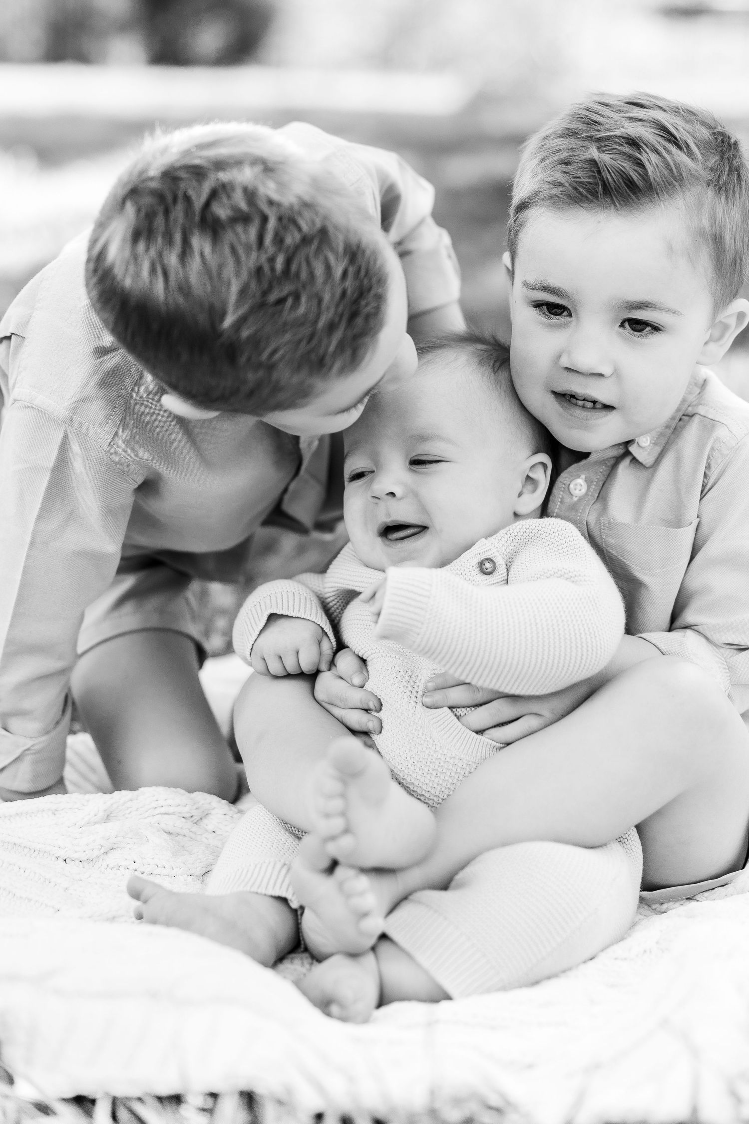 Black and white series of siblings sharing playful and affectionate moments together.