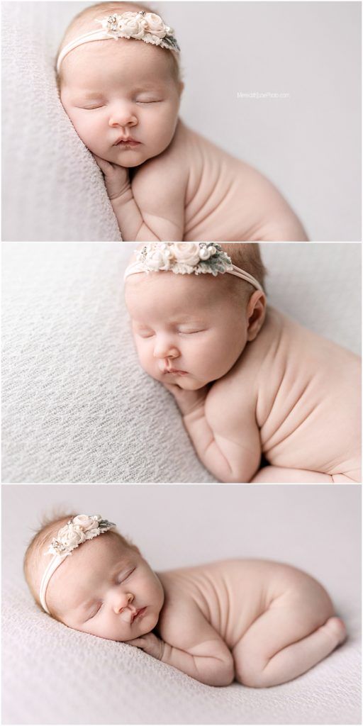Newborn baby sleeping peacefully on white fabric wearing delicate floral headband in professional portrait series.