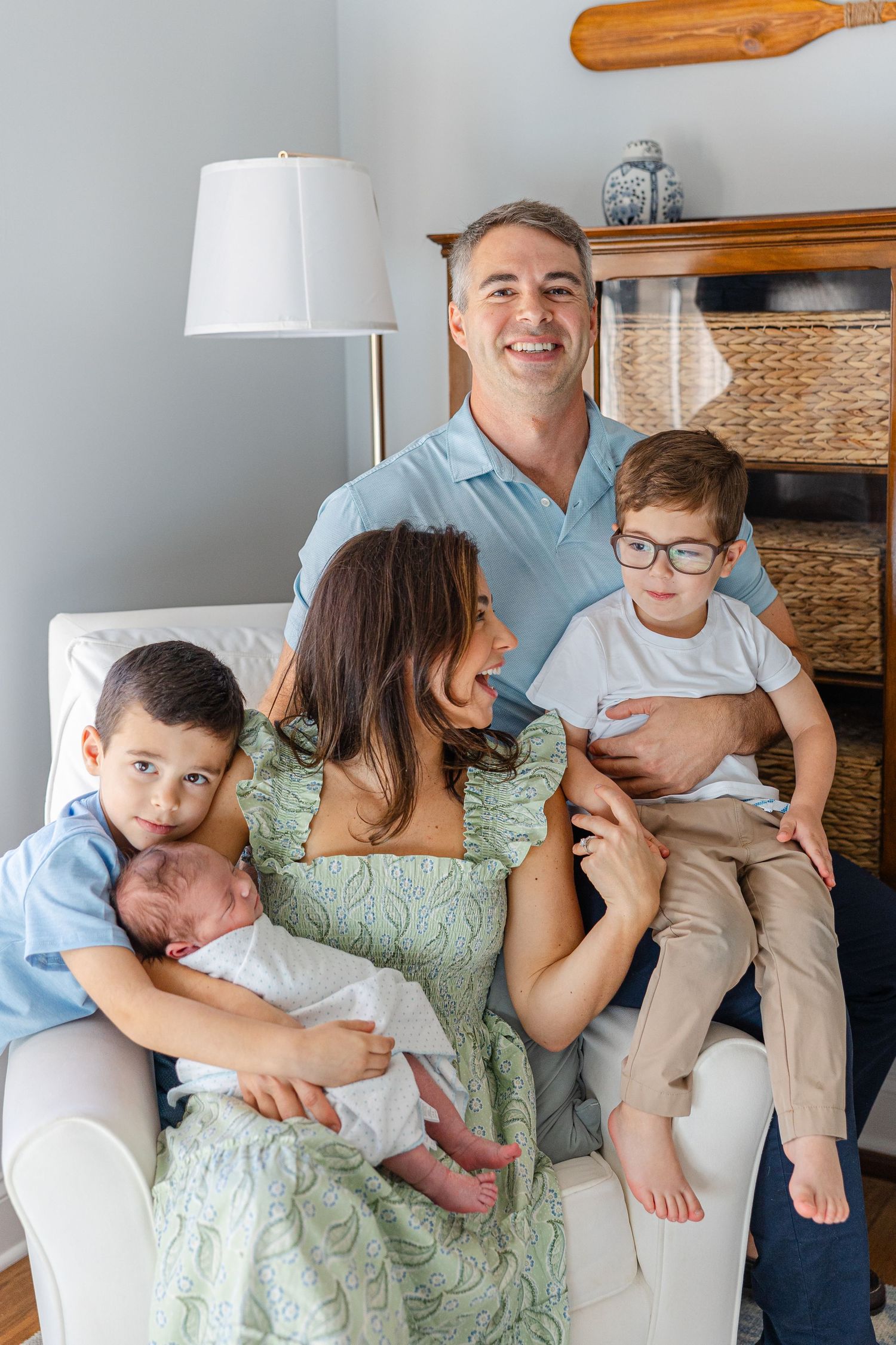 Casual family portrait session on couch with playful interactions.