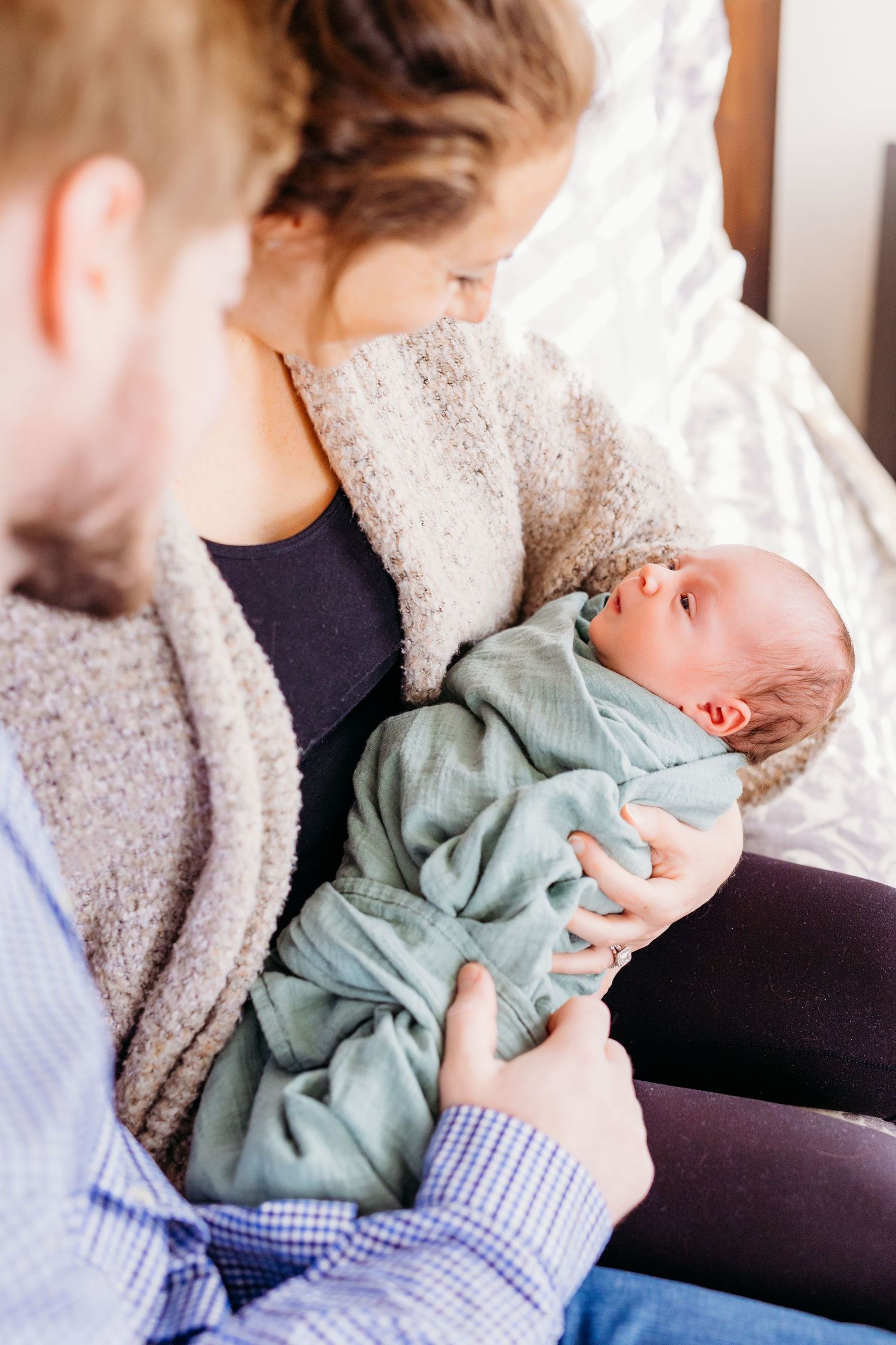 A sequence of intimate photos showing gentle interactions with a sleeping newborn in mint green clothing.