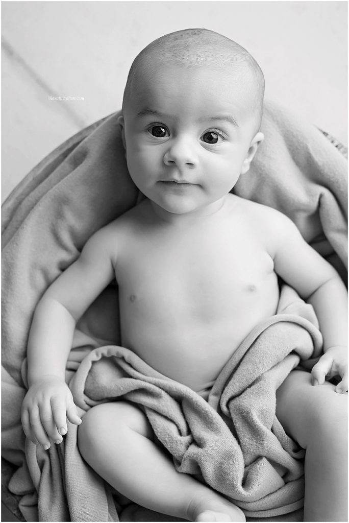 Artistic black and white portraits capturing sweet moments on white fabric.
