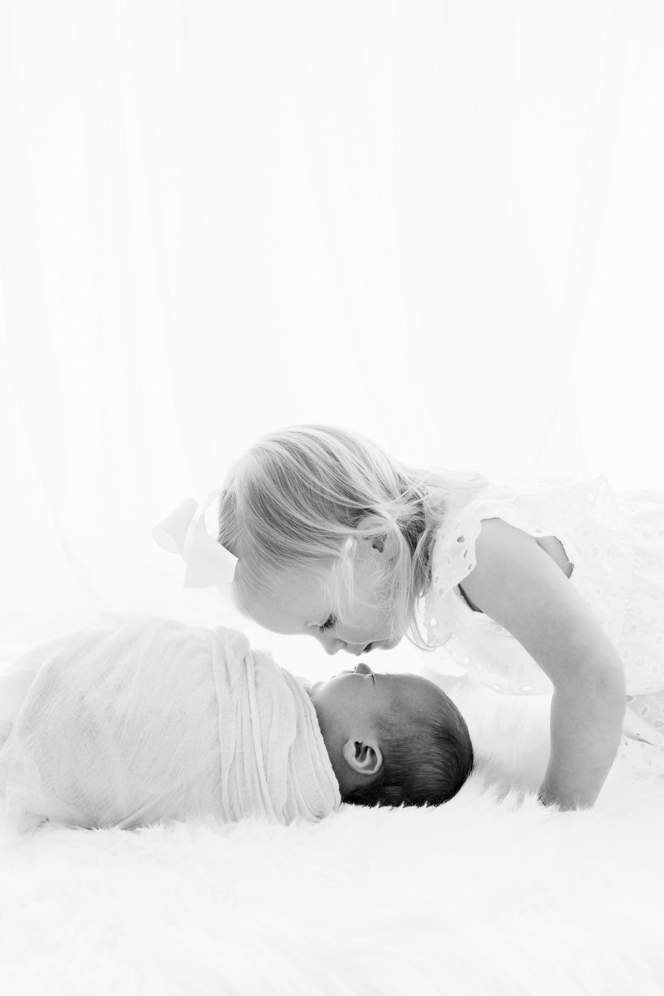 Artistic black and white portrait of mother and baby lying together.