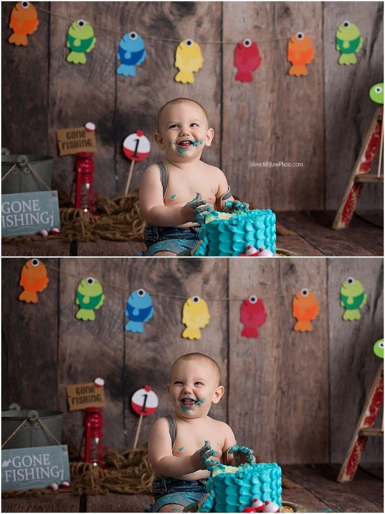 Fishing-themed cake smash photo setup with colorful fish decorations and rustic wood backdrop.