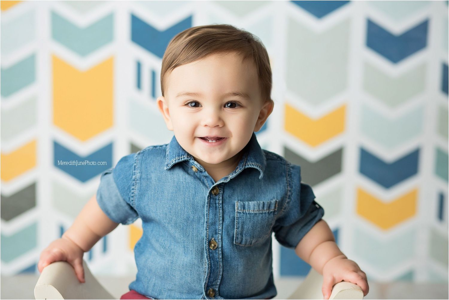 A joyful moment captured against a chevron patterned background with blue and yellow geometric shapes.