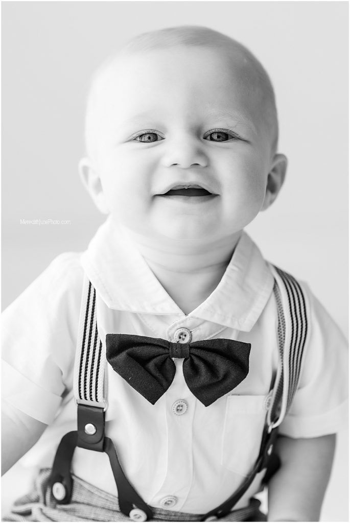 A black and white photo series showing a baby dressed formally in a white shirt, black bowtie and suspenders.