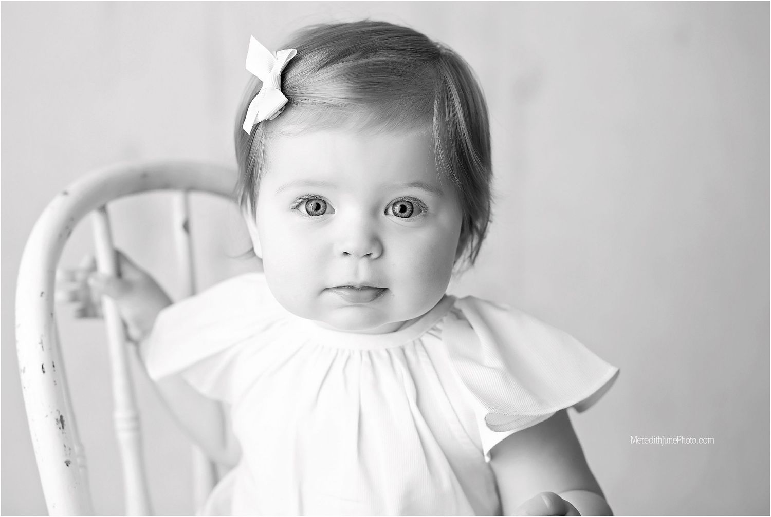 A series of black and white baby portraits showing different expressions and poses against a light background.