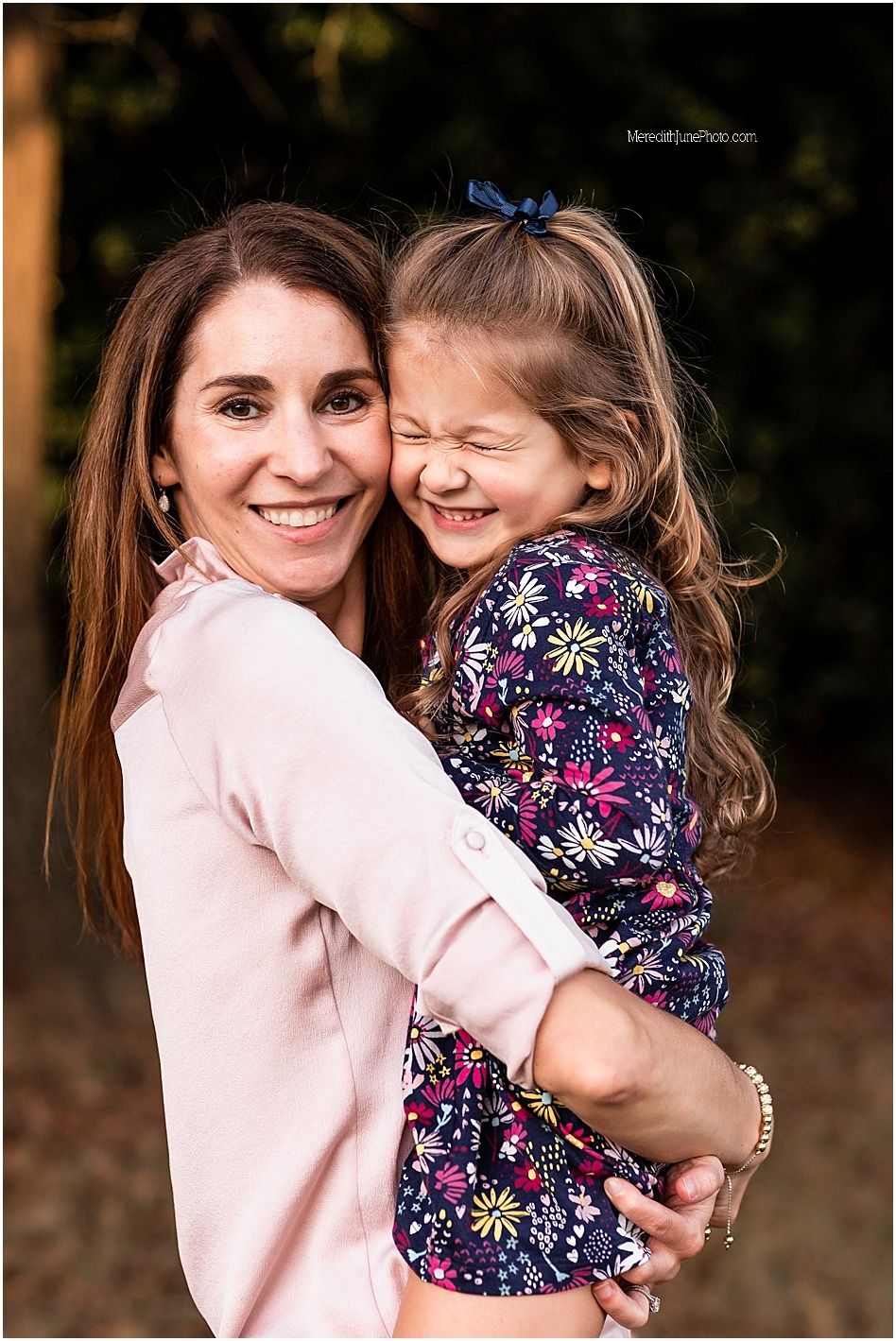 A heartwarming embrace between two people wearing pink and floral prints in an outdoor setting.