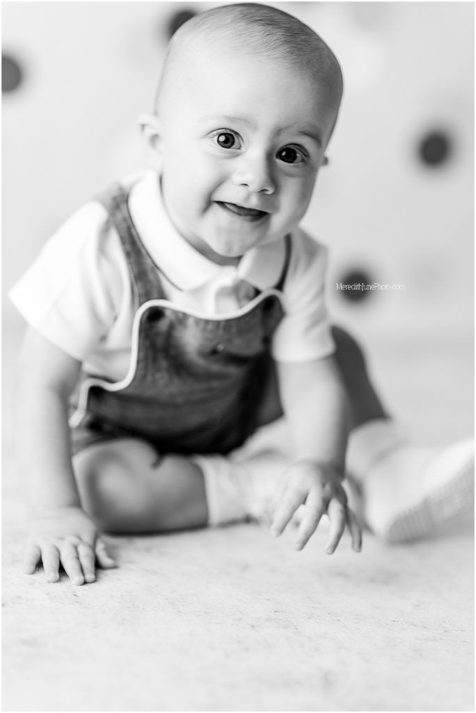 A series of black and white photos showing a baby crawling and exploring on a light colored surface.