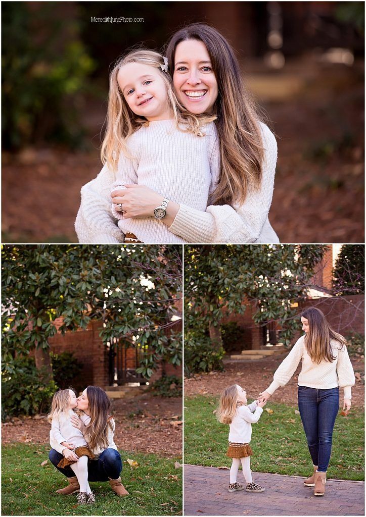 A mother and daughter walking together through a garden path surrounded by blooming white flowers and greenery.