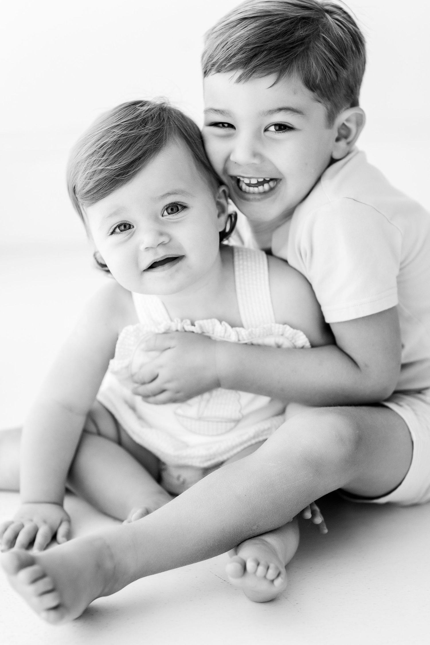 Black and white photos of siblings hugging and laughing together.