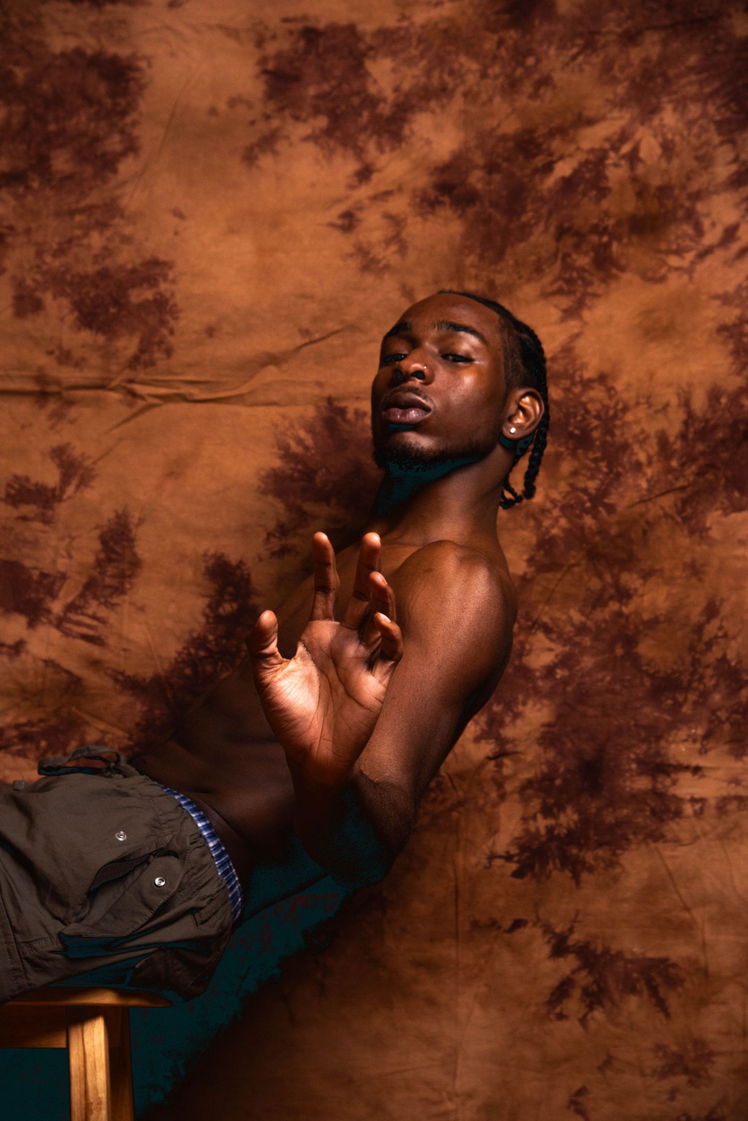 Dramatic artistic portrait series against brown textured backdrop with moody lighting and expressive poses.