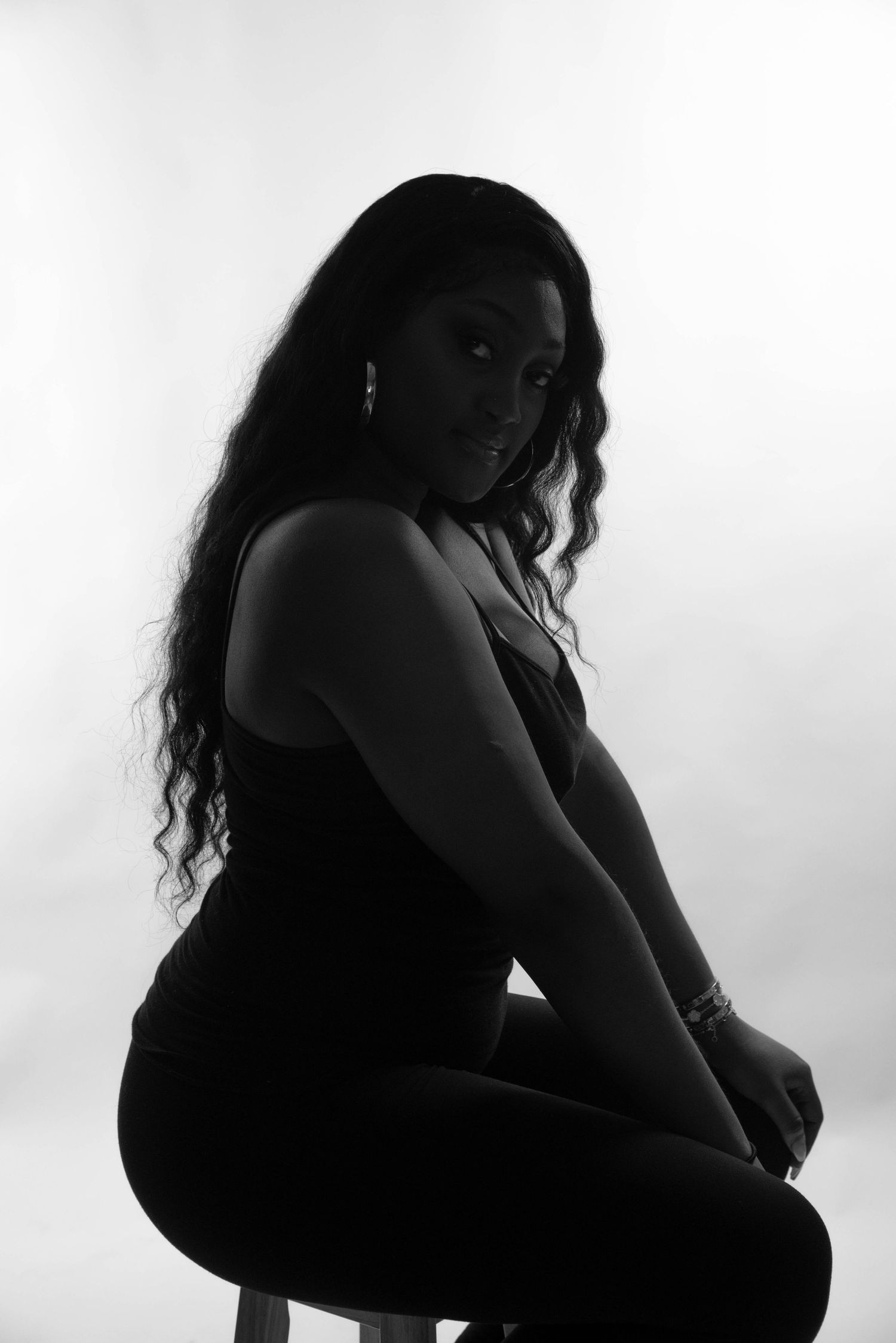 Dramatic black and white silhouette portrait against white background.