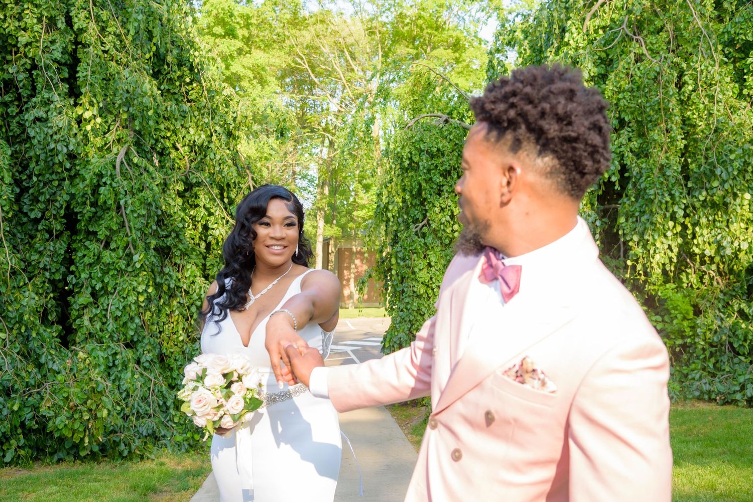 Wedding photo series in lush garden setting with couple in pink and white attire.