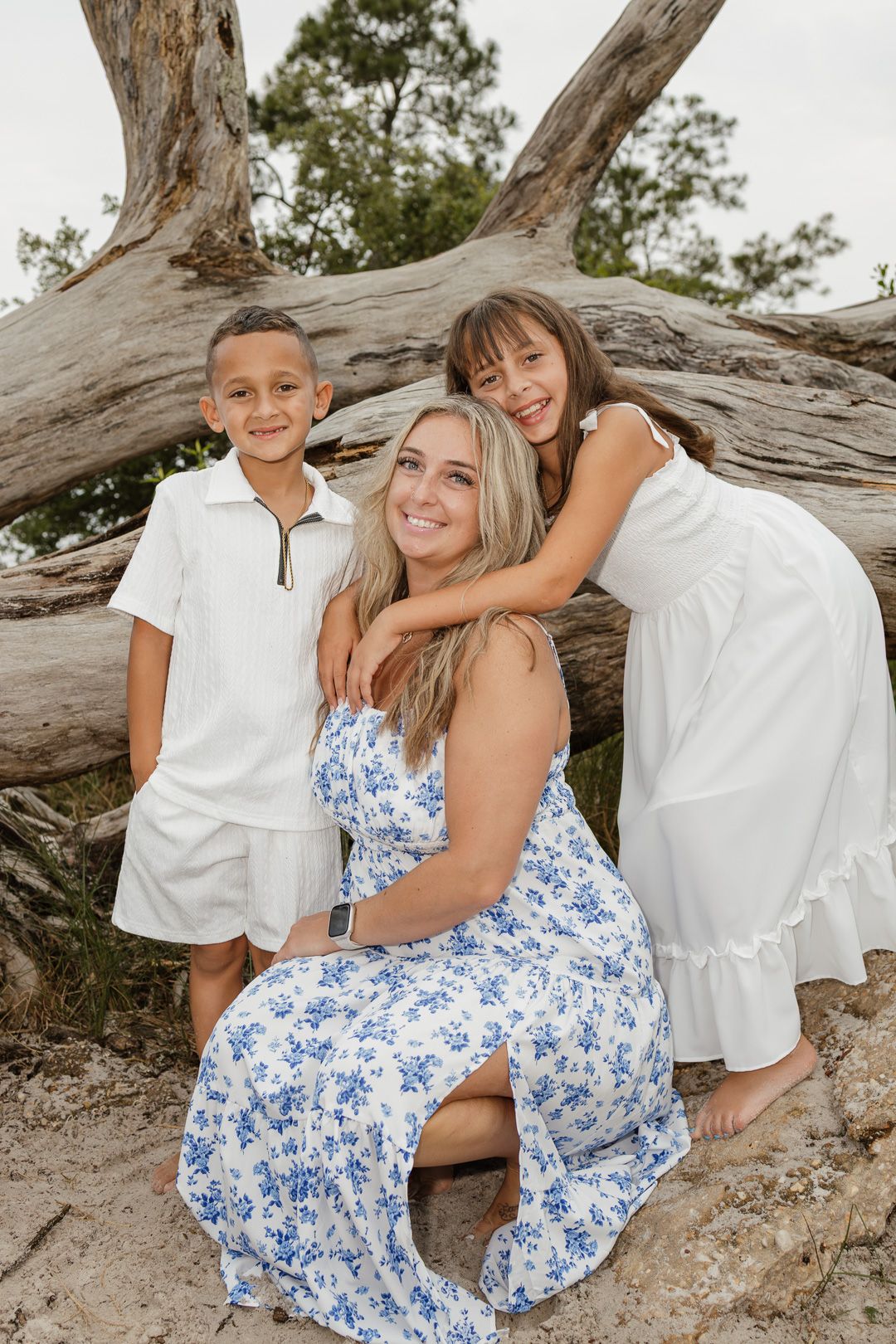 Family embracing on Pensacola Beach during a sunset photography session.