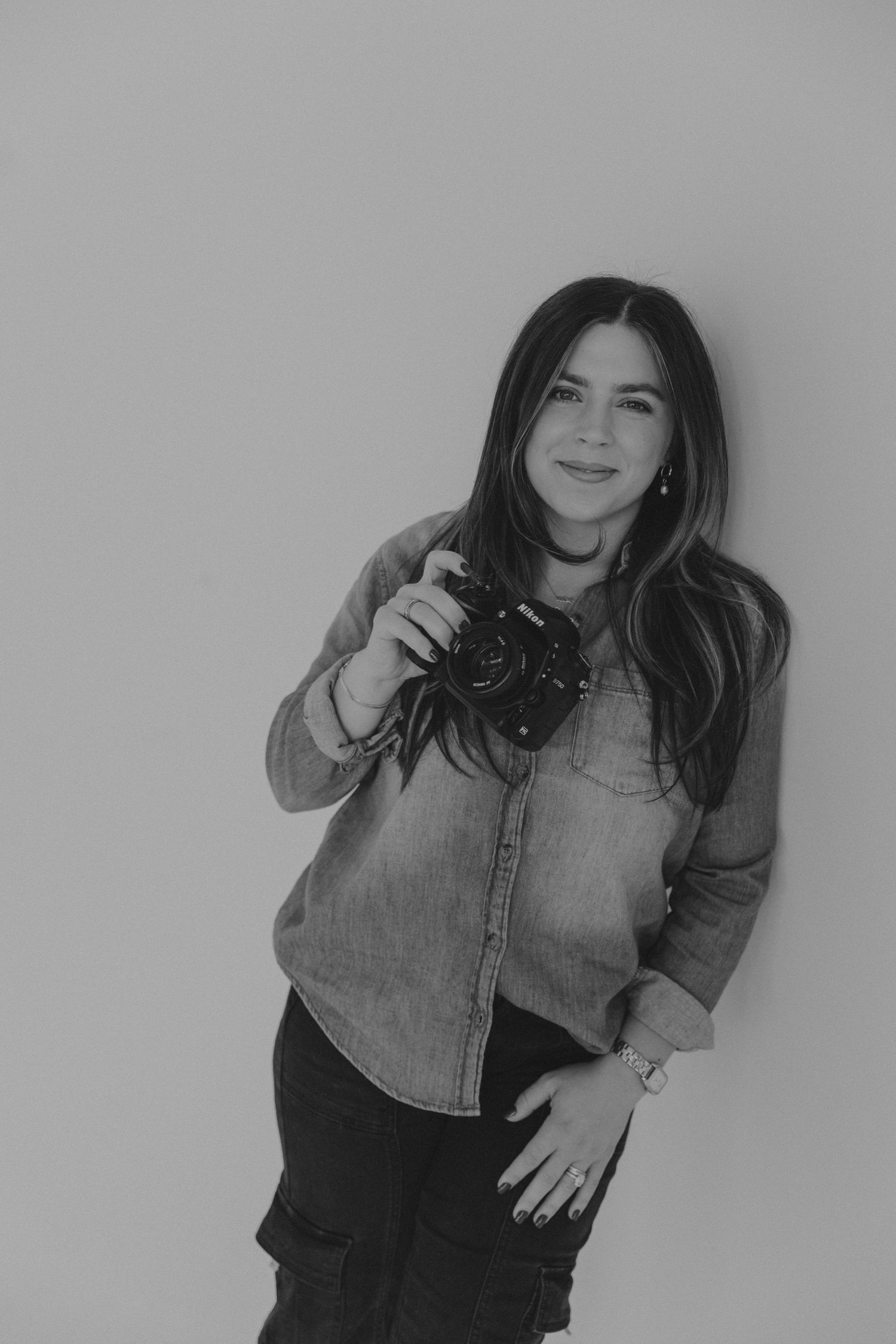 Studio portrait session with black and denim fashion against grey background.