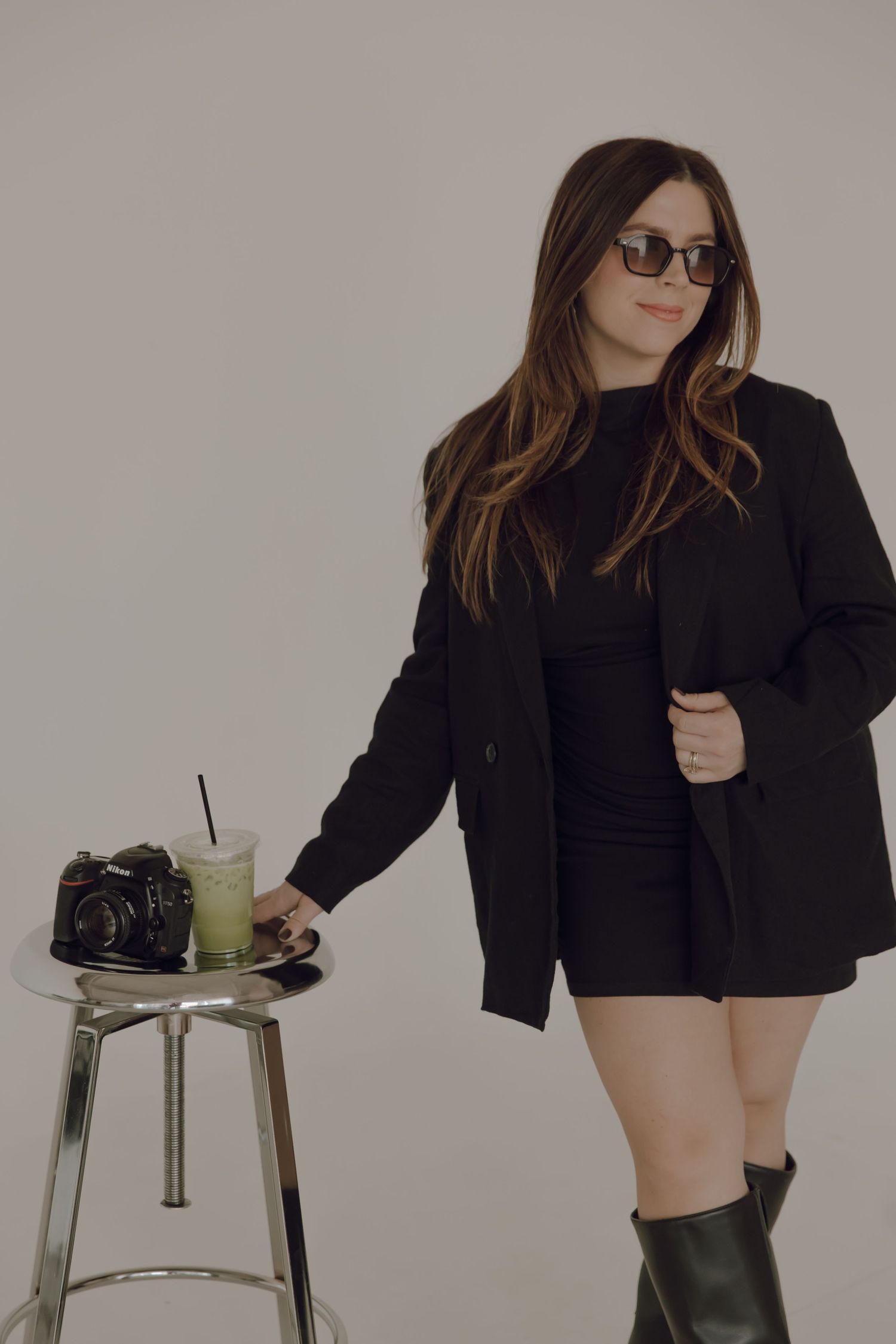Fashion portrait series with sunglasses and black outfit against neutral backdrop.