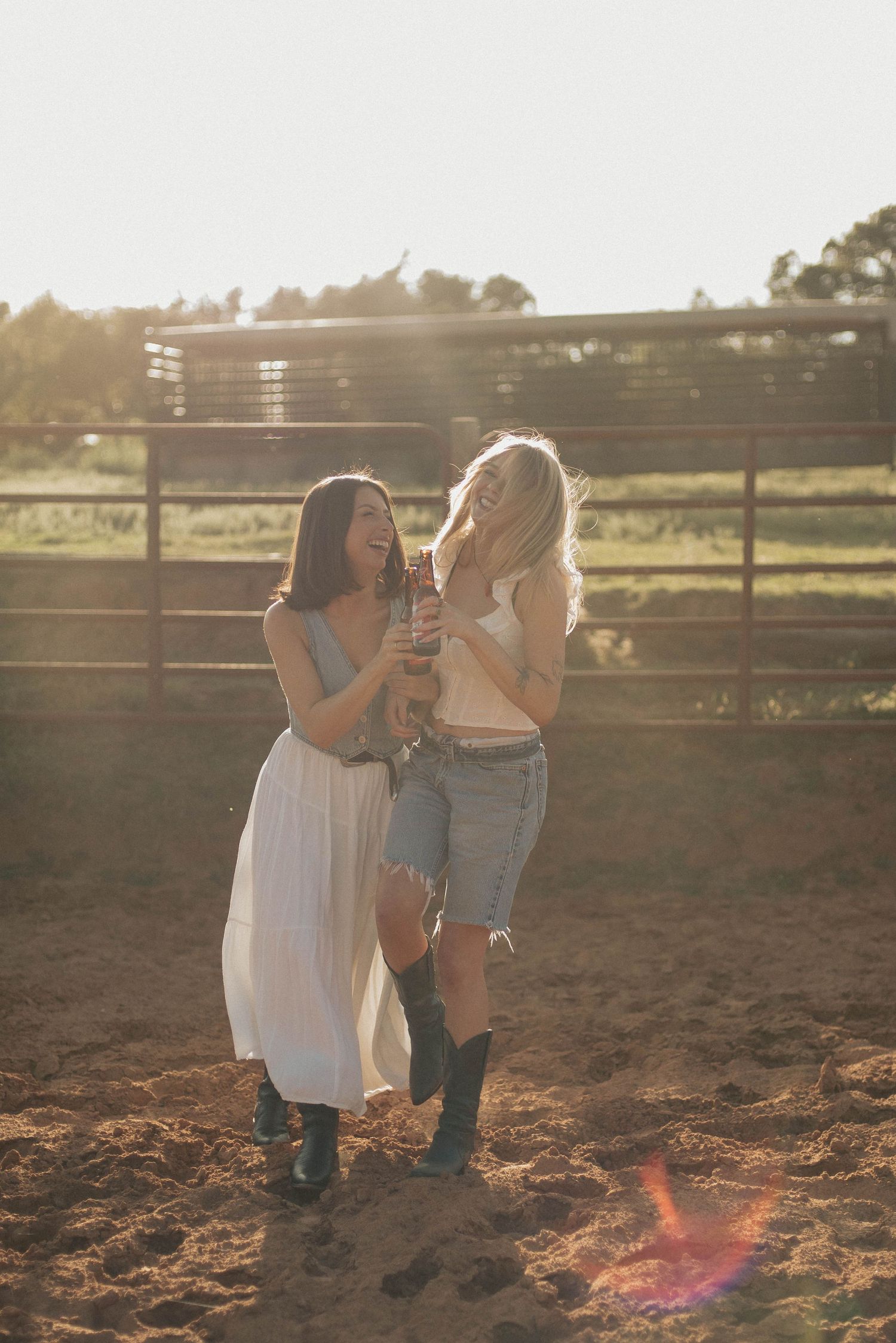 Friends enjoying drinks together in a rustic outdoor setting during golden hour.