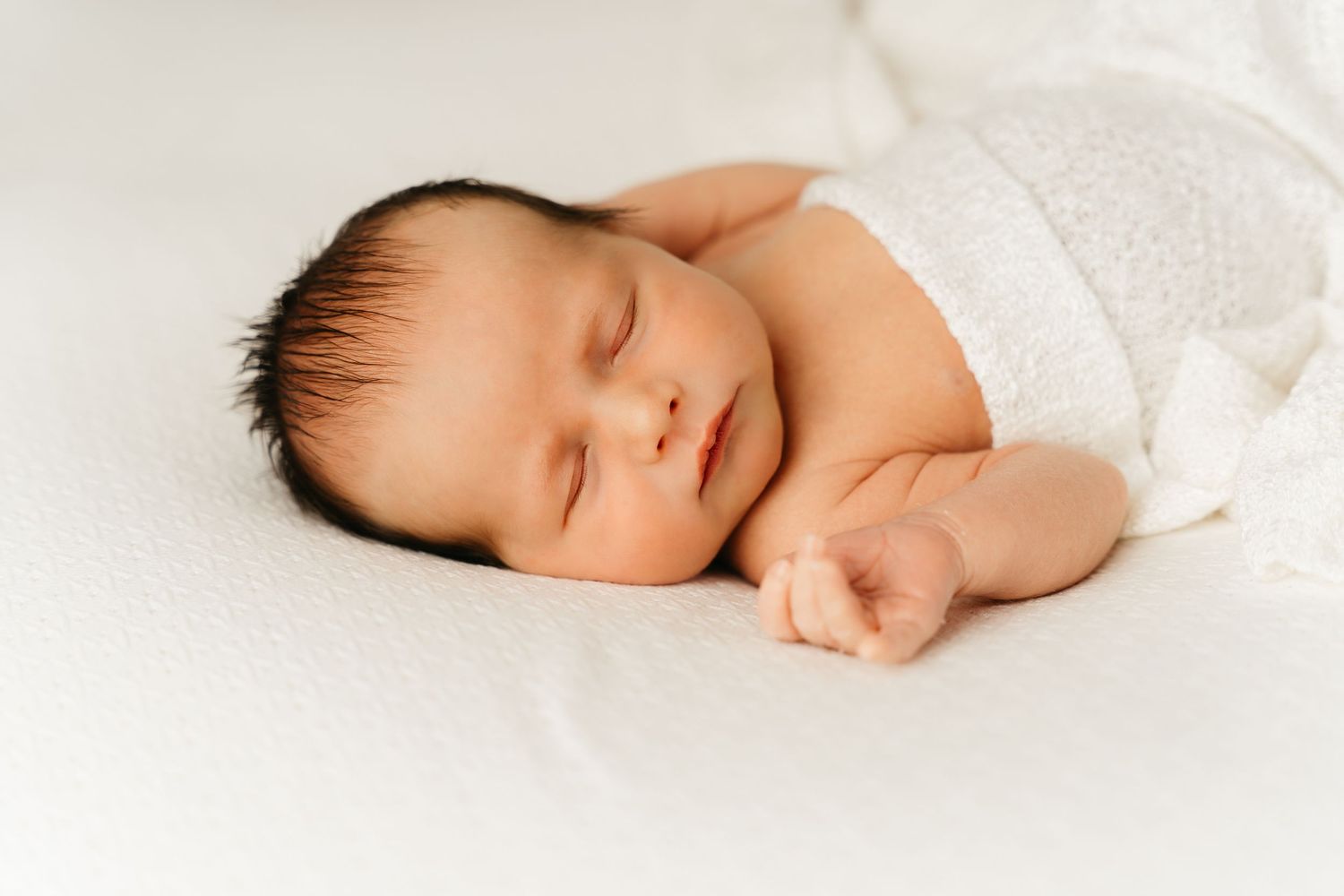 een foto van een slapende baby in een tijdloze setting tijdens een newborn reportage in studio in zandhoven